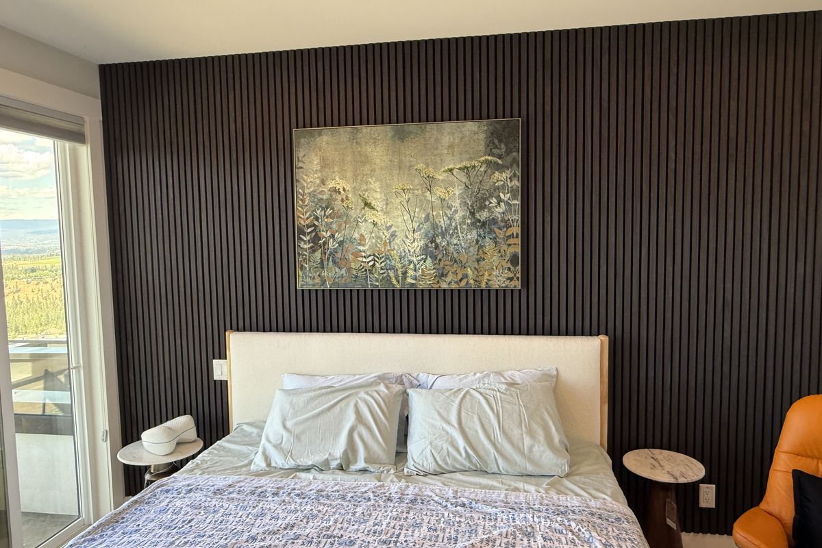 Bedroom wall after — dark wood slat feature wall