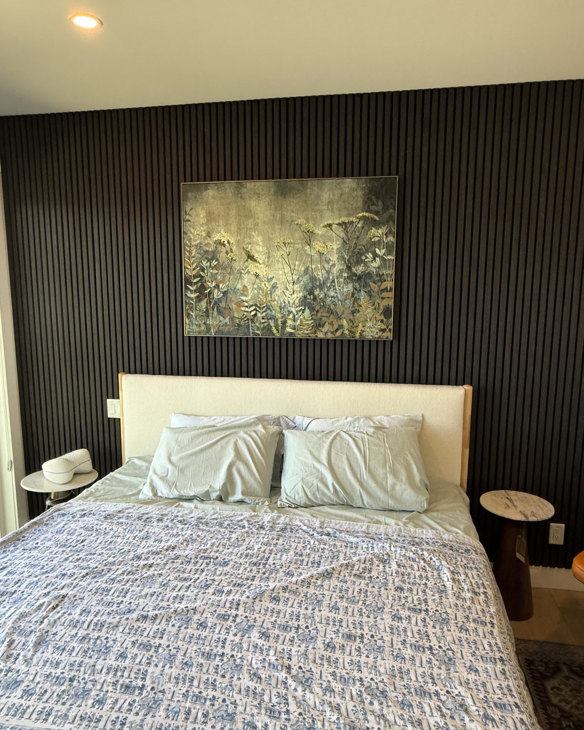 Slat feature wall behind a bed in a primary bedroom